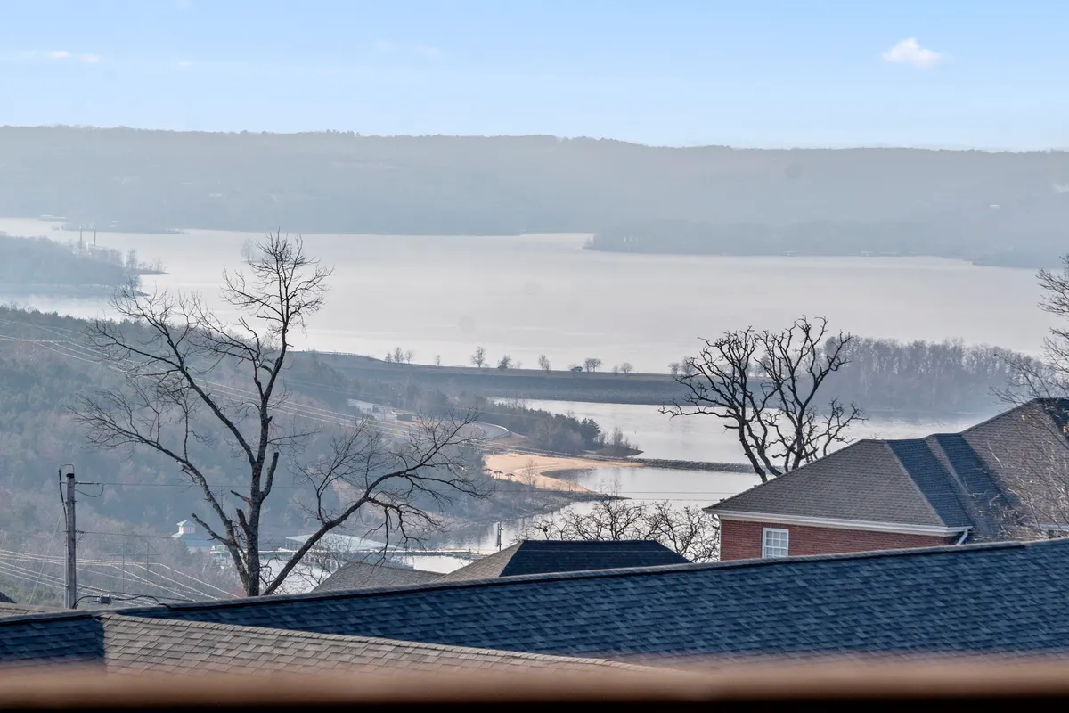 Featuring a serene lake surrounded by hills, bare trees, and sky, this image highlights the natural beauty of the area. The scene evokes tranquil moments by the water, scenic walks, and opportunities for pets to explore nature trails.