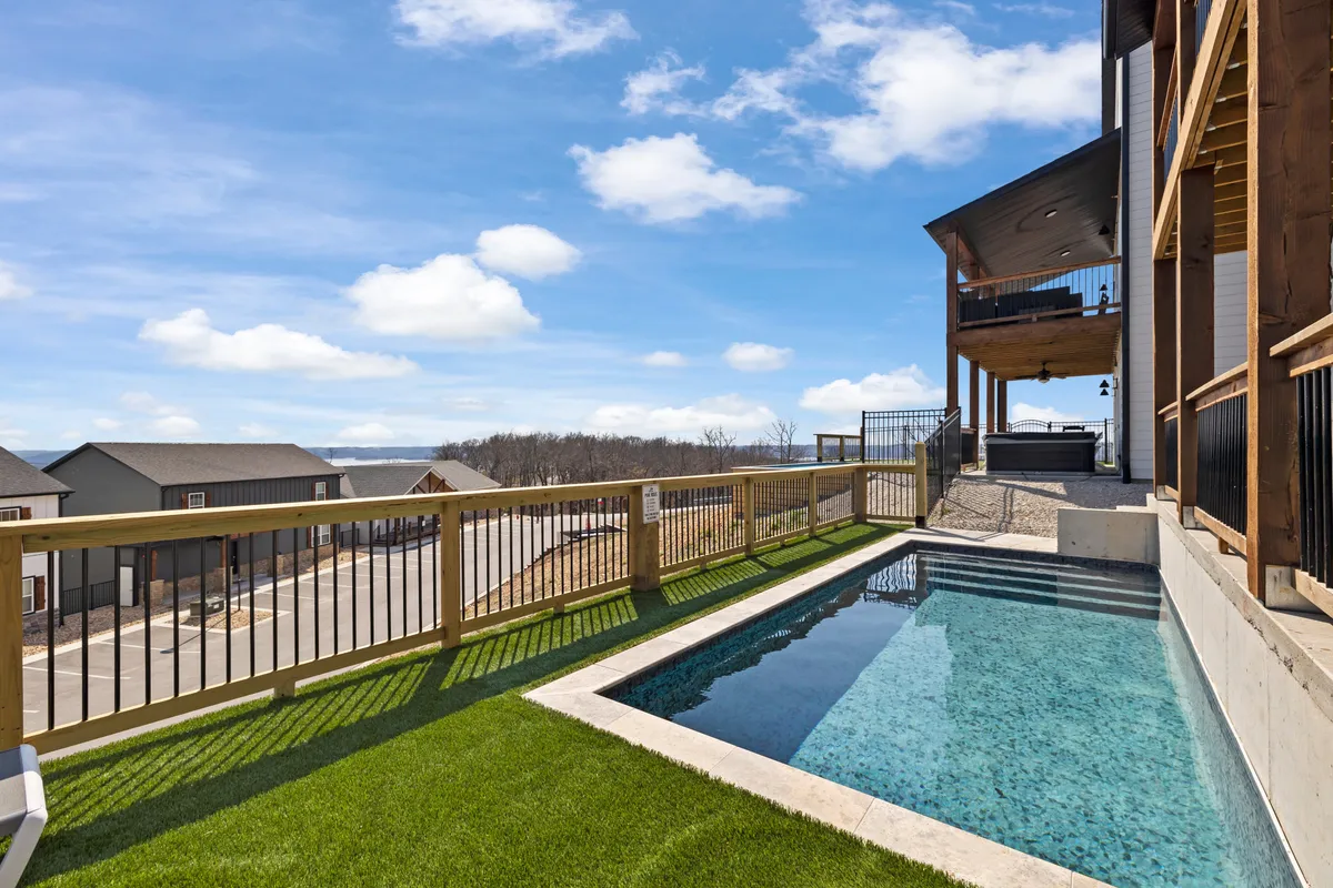 A tranquil exterior shot of the swimming pool and deck area, complete with lounge chairs and a welcoming outdoor seating arrangement. The landscape beyond hints at the serene setting, ideal for swimming, sunbathing, or gathering with family and friends.