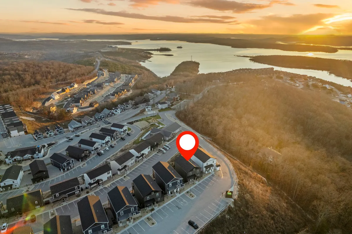 A tranquil view of a lake during sunset, with hills and houses dotting the landscape. The peaceful water and open skies evoke a sense of adventure, relaxation, and connection with nature, hinting at activities like boating, hiking, and family gatherings.