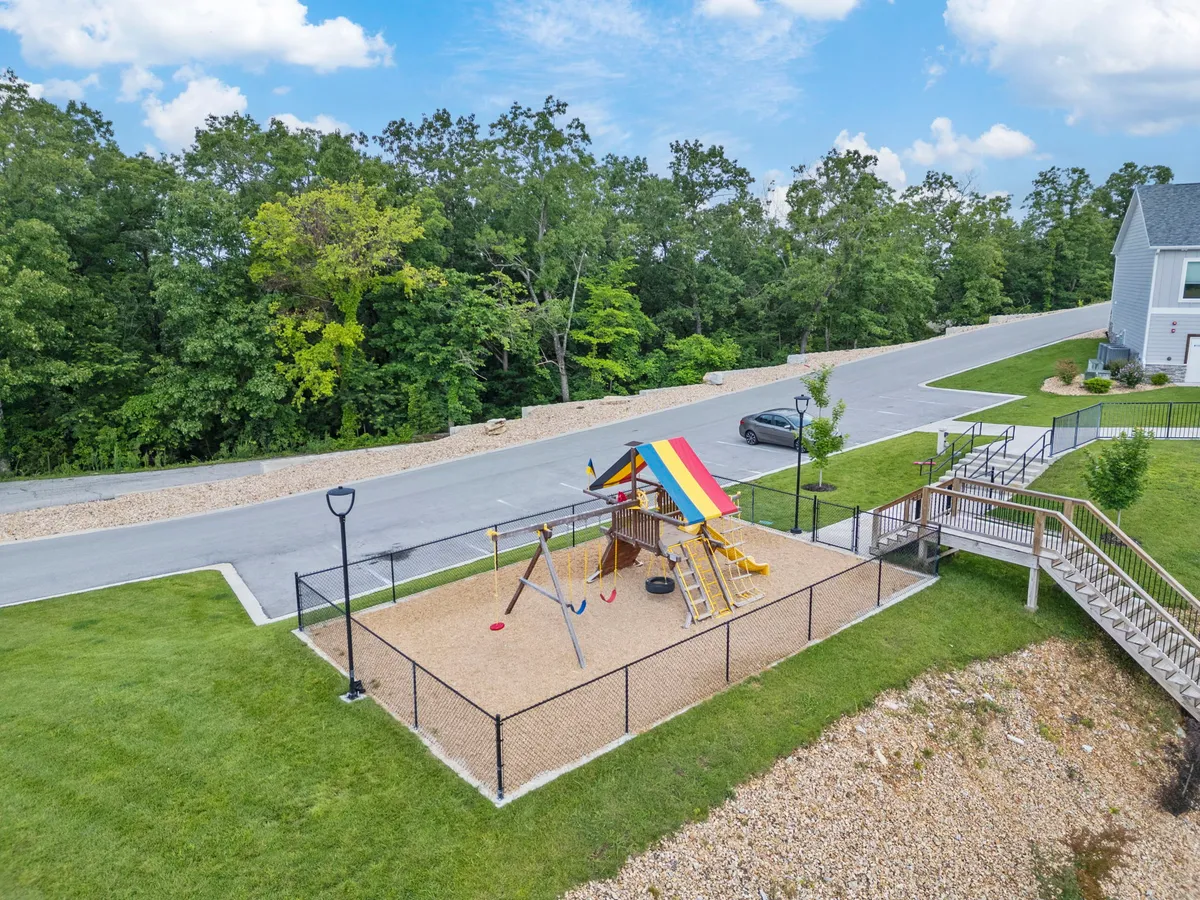 A vibrant, colorful playground structure with swings and a surrounding green landscape. The area is alive with the potential for community play, group activities, and joyful outdoor recreation—perfect for team-building exercises and post-meeting relaxation.